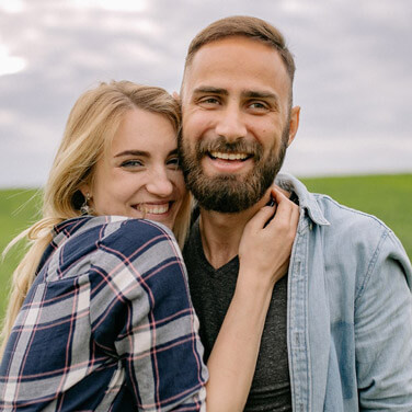 a man and a woman smile and hug